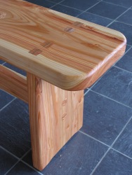 The decorative wedged mortice and tenon joints in the table are echoed here in the accompanying bench.